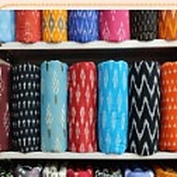 Ikkat cotton fabric rolls on a shelf