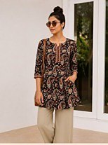 Dark printed short kurti worn with beige trousers